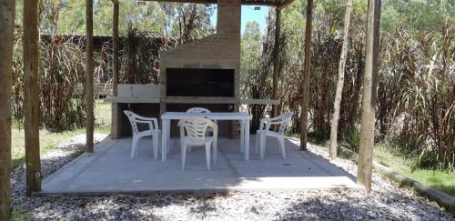 Una mesa y sillas en un patio con chimenea. en Complejo Mirando el Cerro, en Punta Colorada