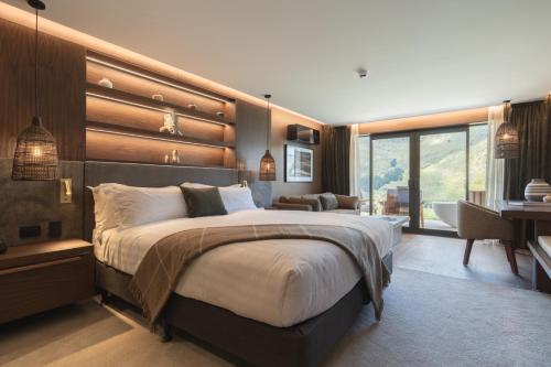 a bedroom with a large bed and a desk at Coronet Ridge Resort in Queenstown