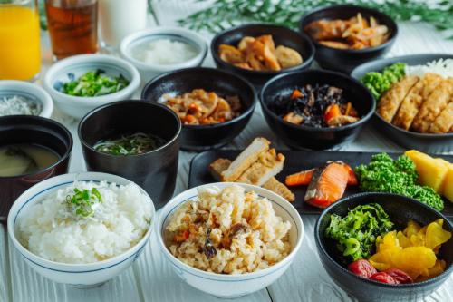 松山市にあるネストホテル松山のさまざまな種類の食べ物が入ったボウルが置かれたテーブル