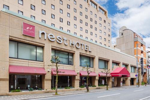 a meerkuth hotel on a city street with a street at Nest Hotel Matsuyama in Matsuyama