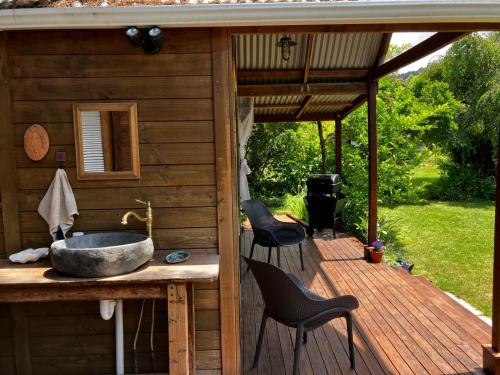 a outdoor bathroom with a sink on a deck at RIMU CABIN At the Bridge in Motungarara