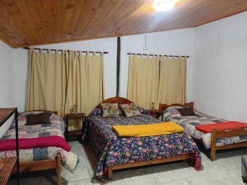 a bedroom with two beds and a wooden ceiling at Las Tres Marias in Valle Hermoso