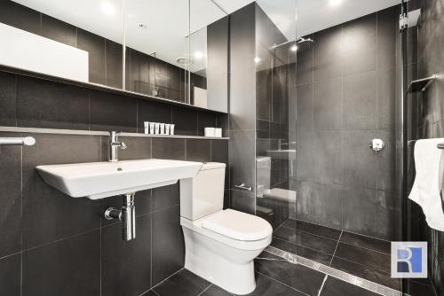 a bathroom with a white toilet and a sink at REST COLLECTION Apartments on Collins Docklands in Melbourne