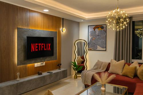 a living room with a couch and a tv at Gold Crest Prime Heights Executive Apartments-DHA Lahore in Lahore