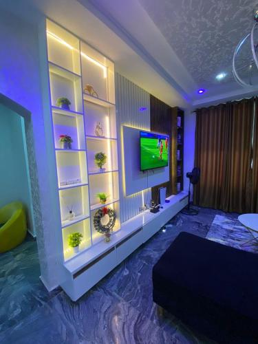 uma sala de estar com uma TV de tela plana na parede em Carolean luxury wuye em Abuja