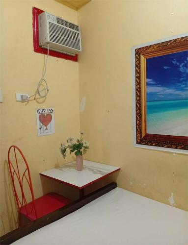 a small table with a red chair and a window at WJV INN Mandaue Centro in Mandaue City