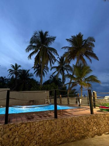 a swimming pool with palm trees in the background at Apto PB Palmar de los vientos in San Bernardo del Viento