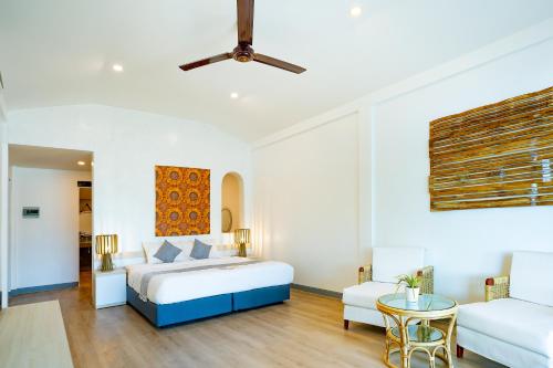 een slaapkamer met een bed, een bank en een tafel bij The Sanctuary Nam Ngum Beach Resort in Vang Vieng