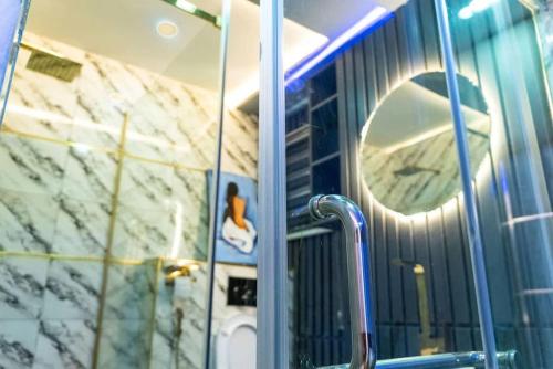 a bathroom with a mirror and a reflection of a sink at Hapton apartment in Abuja