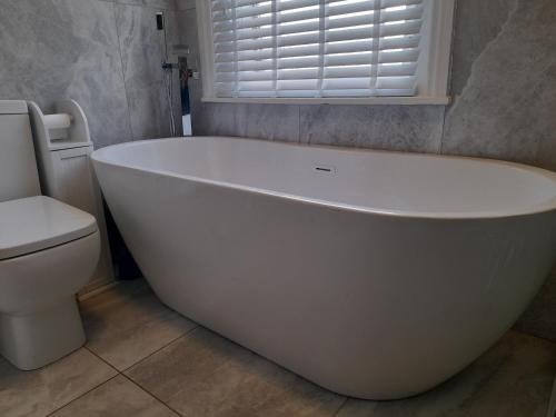 een badkamer met een wit bad en een toilet bij Terrace cottage in Blackpool