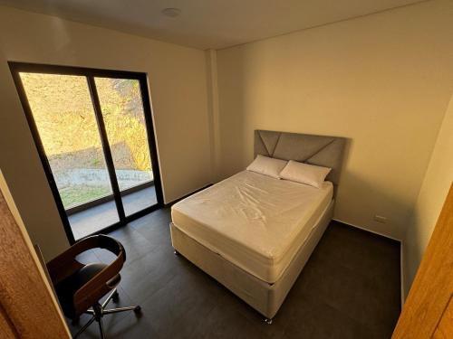 een slaapkamer met een bed, een stoel en een raam bij Luxury estate in San Jerónimo with infinity pool in San Jerónimo