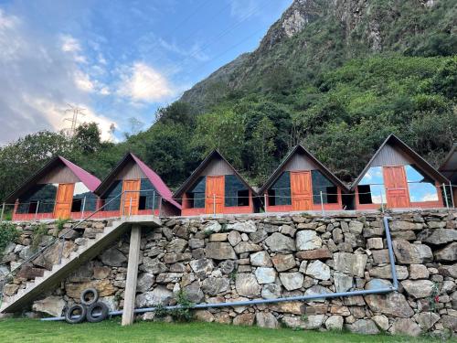 a row of houses on a stone wall at AndeStay Hostel Colpapampa in Colcapampa