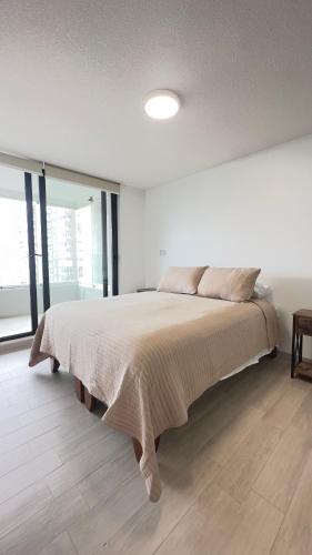 una camera da letto con un letto grande in una stanza bianca di Departamento Concon Costa de Montemar a Concón