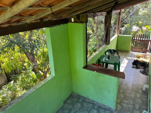 a green porch with a green door and a chair at CANTINHO do SILENCIO in Morro de São Paulo