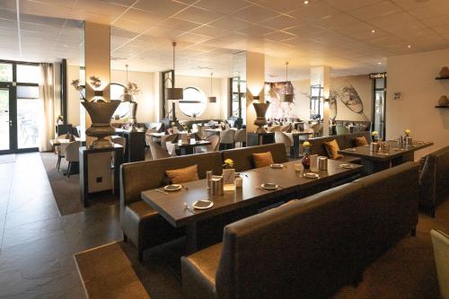 ein Speisesaal mit Tischen und Stühlen und ein Restaurant in der Unterkunft Bernstein Salzlandcenter in Staßfurt