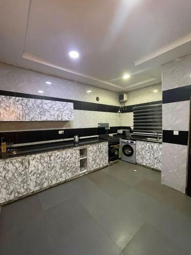 una cocina con azulejos blancos y negros en la pared en Cozy home wuye, en Abuja