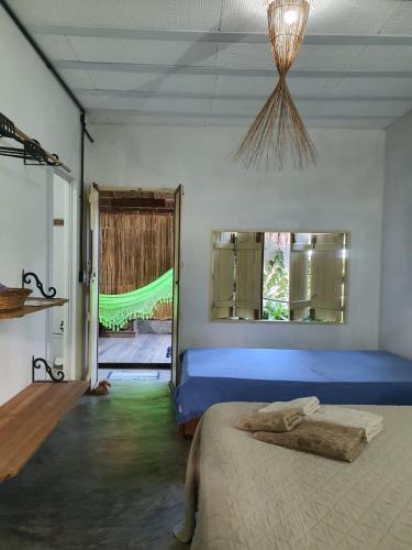a bedroom with a blue bed and a window at Parador Algaroba in Japaratinga
