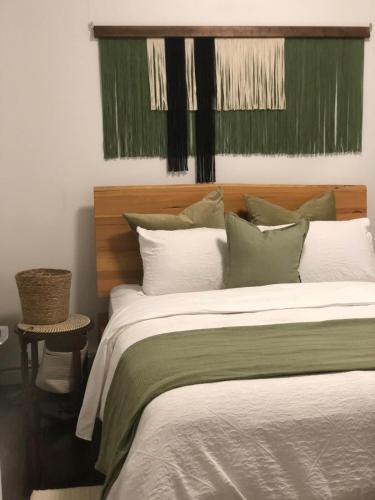 een slaapkamer met een groot bed met groene en witte kussens bij Pet Friendly Acer Arena Accommodation in Sydney