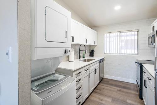 a white kitchen with a sink and a dishwasher at Spacious 2 Bedroom, 2 Bath, Pool, Free Parking, Gym in Scottsdale