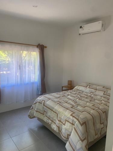 a bedroom with a bed and a window at La Camelia in Juan L. Lacaze
