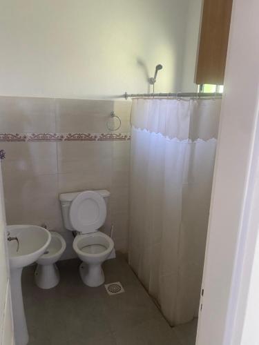 a bathroom with a toilet and a sink at La Camelia in Juan L. Lacaze