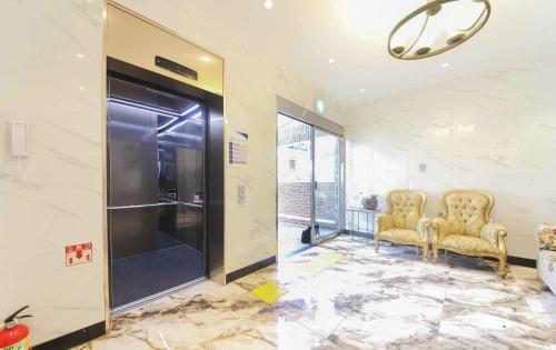 um átrio com duas cadeiras e um elevador em Sea Cliff Hotel Jeju em Jeju