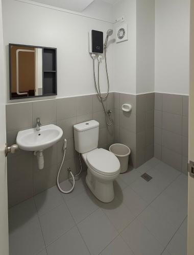 a bathroom with a toilet and a sink at The Gilded Blue Nest in Mandaue City