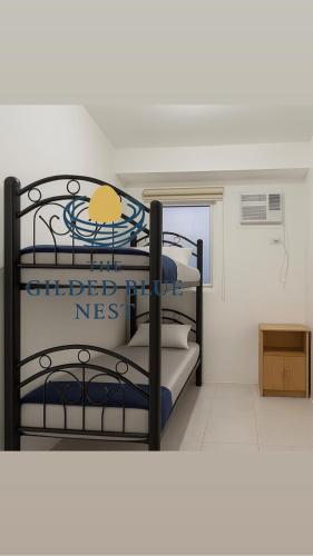 two bunk beds in a room with a window at The Gilded Blue Nest in Mandaue City