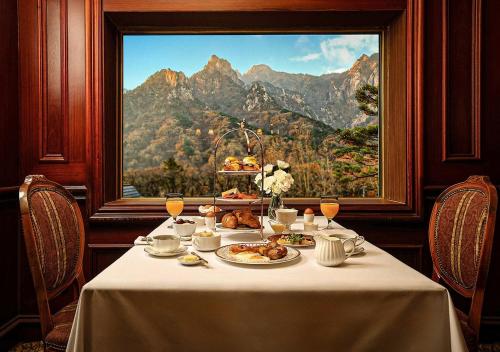 KensingtonHotel Seorak في سوكشو: طاولة مع طبق من الطعام أمام النافذة