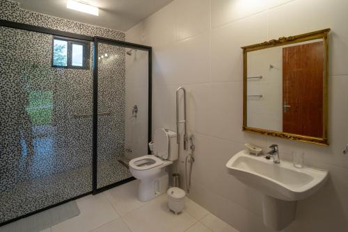 a bathroom with a shower and a toilet and a sink at San Cosme y Damian Lodge & Spa in San Cosme y Damián