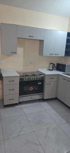 una cucina con fornelli e mobili bianchi di Zim Oasis a Portmore