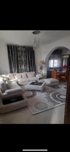 a living room with white couches and a table at Vila Xhipe in Korçë