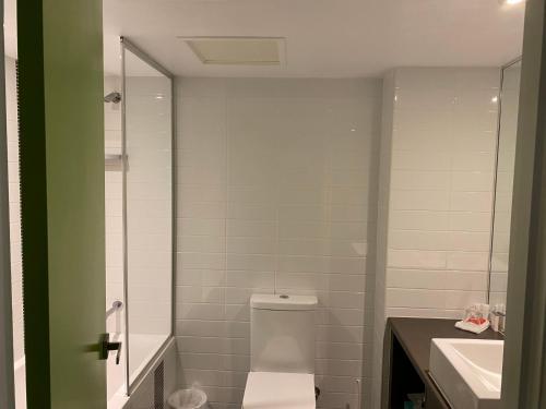 a bathroom with a toilet and a sink at Mackay Oceanside Central Hotel Official in Mackay