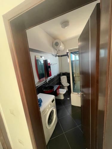 a bathroom with two toilets and a sink and a washing machine at Vila Xhipe in Korçë