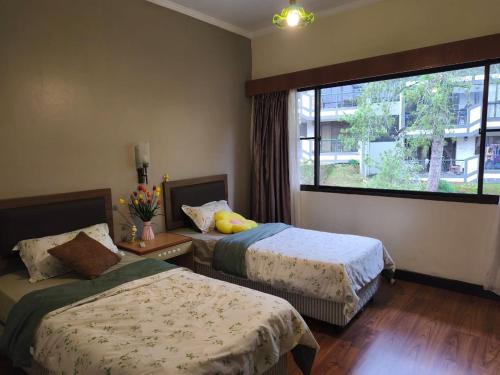 um quarto com duas camas e uma janela grande em Cameron Highlands homestay em Brinchang