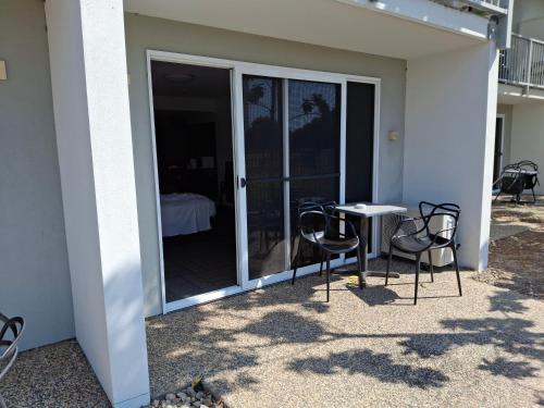 a patio with two chairs and a table with a balcony at Mackay Oceanside Central Hotel Official in Mackay