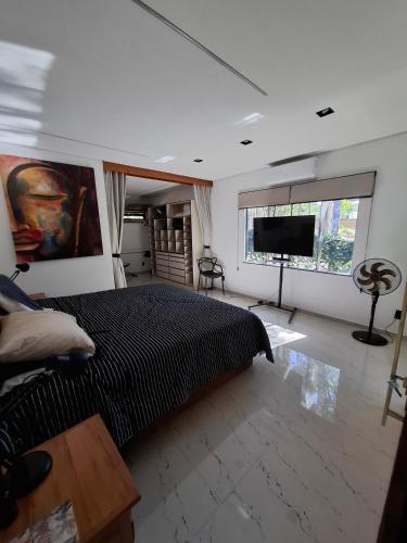 een slaapkamer met een bed en een flatscreen-tv bij Natureza in Porto Seguro