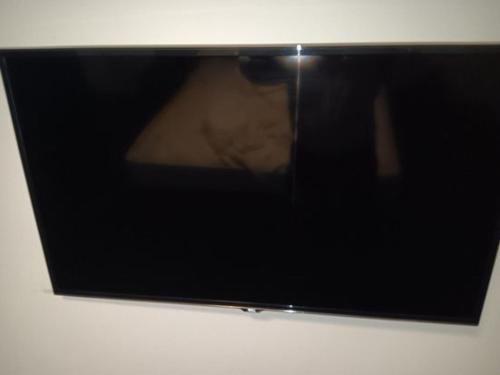 um ecrã de televisão com uma reflexão de pessoas nele em Mackay Oceanside Central Hotel Official em Mackay