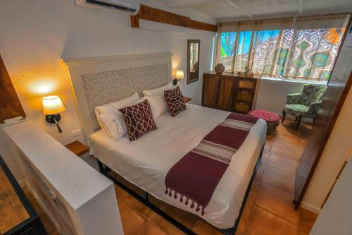 a bedroom with a large bed with pillows and a window at Stylish Studio in the Heart of Zona Romántica in Puerto Vallarta