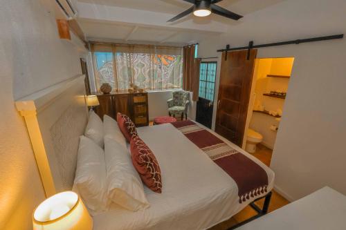 a bedroom with a bed with pillows and a window at Stylish Studio in the Heart of Zona Romántica in Puerto Vallarta