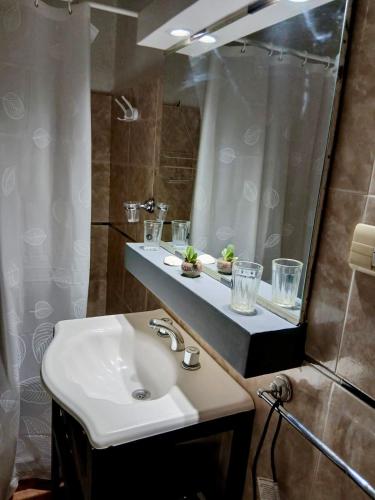 une salle de bain avec un lavabo et une douche avec un miroir dans l'établissement Dpto Céntrico con Asador, à Chilecito