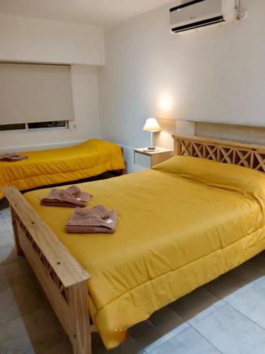 deux lits dans une chambre avec des draps jaunes dans l'établissement Dpto Céntrico con Asador, à Chilecito