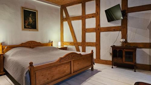 ein Schlafzimmer mit einem Bett und einem Fernseher an der Wand in der Unterkunft Haus Anastasia in Stolberg i. Harz