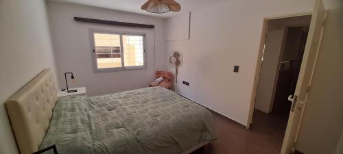 ein Schlafzimmer mit einem Bett und einem Fenster in der Unterkunft Complejo Solares in Villa Carlos Paz