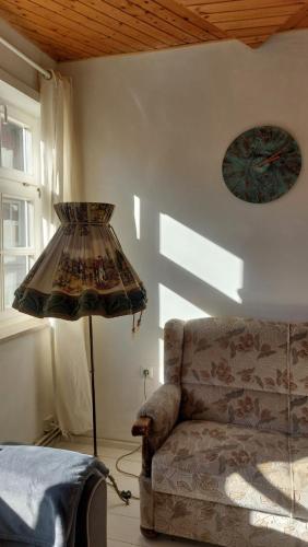 ein Wohnzimmer mit einer Couch und einer Uhr an der Wand in der Unterkunft Haus Anastasia in Stolberg i. Harz