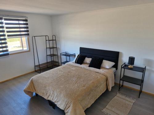 um quarto com uma cama e duas mesas e uma janela em Entre Quebradas y Loicas em Algarrobo