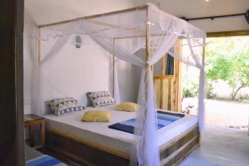 una camera da letto con un letto a baldacchino di Solara Arugam Bay ad Arugam