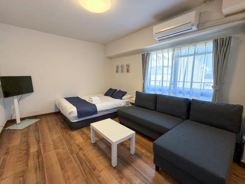 un soggiorno con un divano e un letto di OUCHI HOTEL Tokaichi a Hiroshima