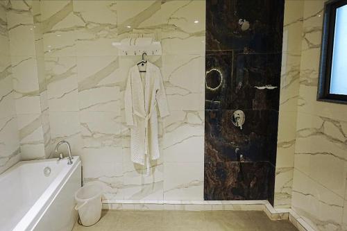 a bathroom with a bath tub and a stone wall at LP Regency in Pune