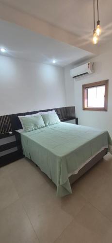 a bedroom with a large bed in a room at Suites Novas in Cabo Frio